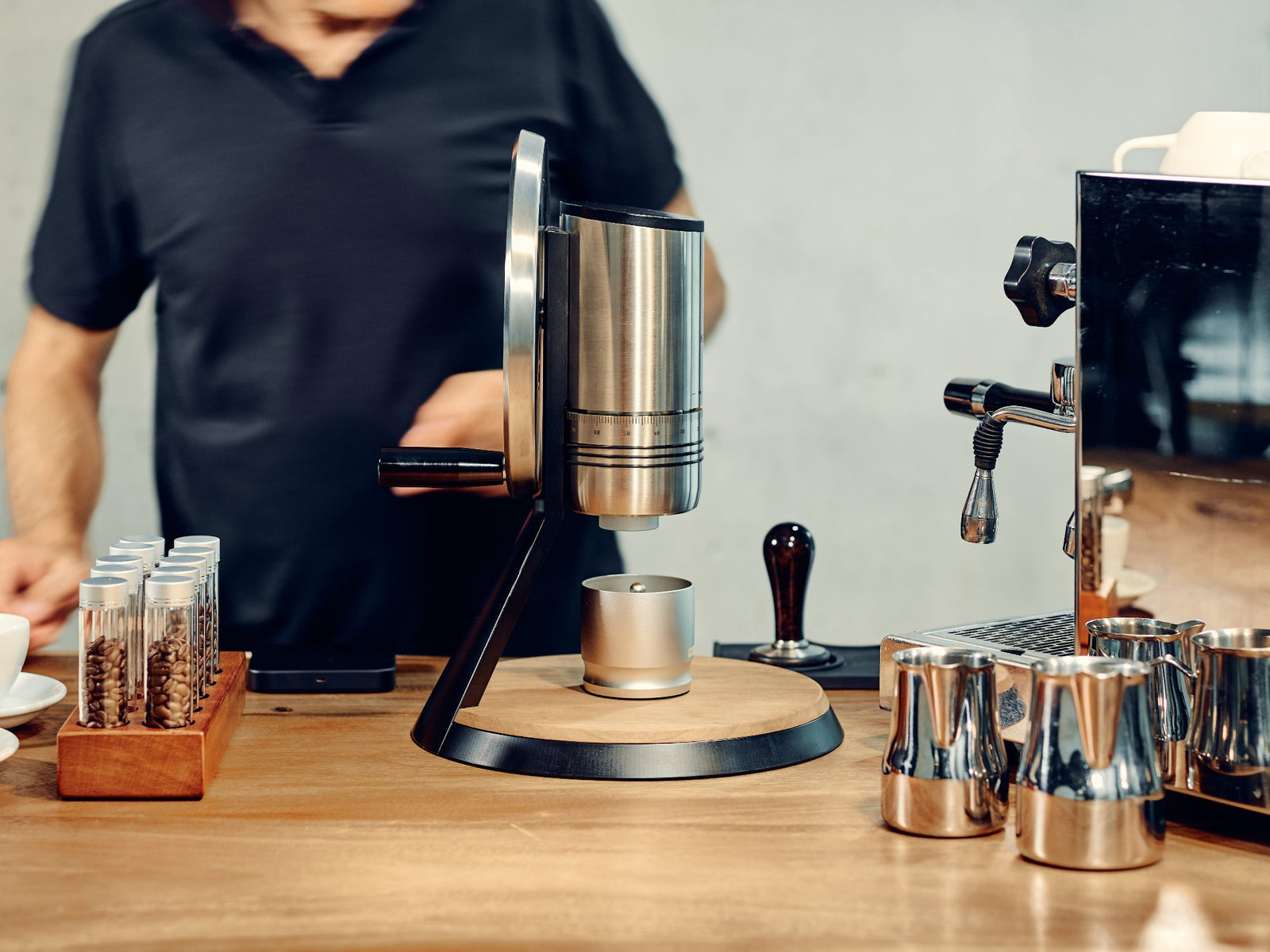 The NECCST Series 1 manual grinder next to an Espresso Machine.